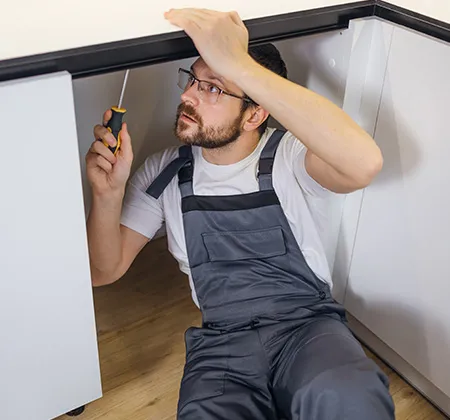 Ein Handwerker beim Abbau eines Küchenunterschranks