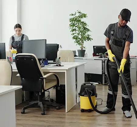 Zwei Putzkräfte bei der gründlichen Büroreinigung